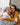 A younger woman with curly hair smiles while hugging an older woman with grey hair in a living room.
