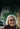 Woman with white hair and glasses smiling outdoors
