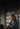 Woman reading a book in a library with bookshelves in the background