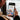 Person holding a smartphone with a video call to an elderly person on a couch.