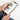 Person holding a smartphone with a YouTube app open on a white background